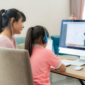 Parent assisting their child with online studies