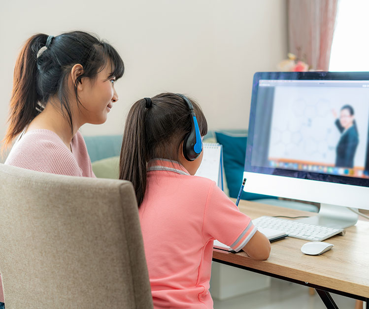 Parent assisting their child with online studies