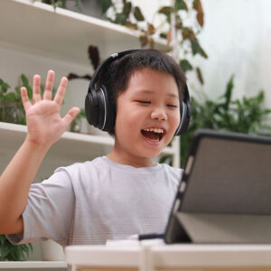 Cheerful child using a tablet for online learning at New Start Education online class